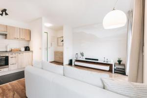 Il comprend un salon avec un canapé blanc et une cuisine. dans l'établissement Modernes Apartment mit Heimkino in Dresden, à Dresde
