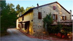 ein altes Steingebäude mit einer angrenzenden Straße in der Unterkunft Podere Lamaccia in Cetona
