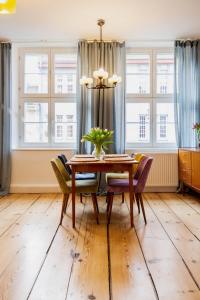 a dining room with a table and chairs and windows at Zeglarska Apartament in Toruń