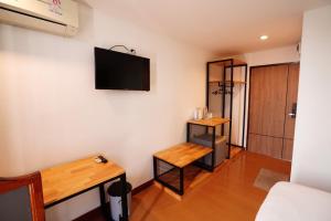 a living room with a tv on the wall at Windsor Hotel in Nakhon Phanom