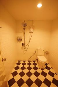 a bathroom with a toilet and a checkered floor at Windsor Hotel in Nakhon Phanom