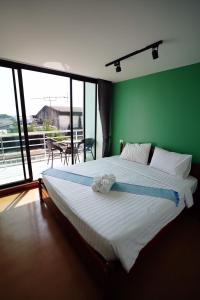 1 dormitorio con 1 cama grande y pared verde en Windsor Hotel en Nakhon Phanom
