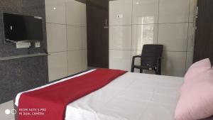 a bedroom with a bed with a red blanket on it at Sar Raj S R RESIDENCY in Vellore