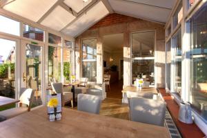 a conservatory with a table and chairs and windows at The Castleton in Swanage