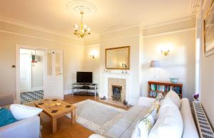 a living room with a white couch and a fireplace at The Castleton in Swanage