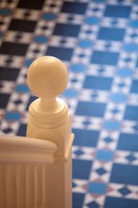 a plastic man sitting on a railing in front of a blue and white floor at The Castleton in Swanage