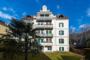 a building with a palm tree in front of it at Lara's Guesthouse in Merano