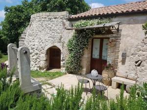 a stone house with a table and chairs in front of it at Masseria Sucéa in Martano