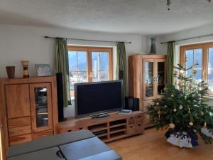a living room with a television and a christmas tree at Rackhof in Oberlienz