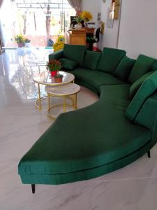 a living room with a green couch and a table at Kim Lien Phu Quoc Guesthouse in Phú Quốc