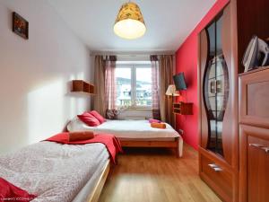 a small bedroom with two beds and a window at Apartamenty Skaldowie in Zakopane