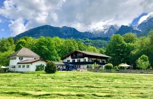 dom w polu z górami w tle w obiekcie FeWo Schneewinkllehen w mieście Schönau am Königssee