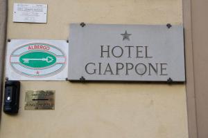 a sign for a hotel hang on a wall at Hotel Giappone in Florence