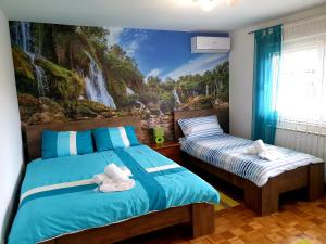 1 dormitorio con 2 camas y un mural con cascada en Apartment Mirela, en Sarajevo