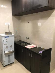 a kitchen with a sink and a refrigerator at ELLIOTT INN A.C DORMITORY in Mumbai