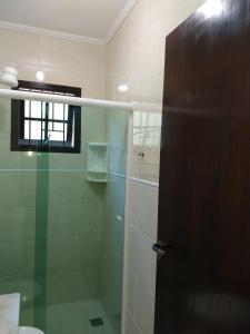 uma casa de banho com um chuveiro e uma porta de vidro em Casa Gomes Itagua em Ubatuba