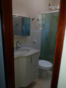 uma casa de banho com um lavatório, um chuveiro e um WC. em Casa Gomes Itagua em Ubatuba
