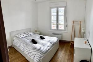 - une chambre dotée d'un lit avec des draps noirs et blancs dans l'établissement L’Heure Bleue, au Crotoy