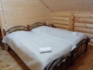 een slaapkamer met een bed in een blokhut bij Cottage house Niniela in Batoemi