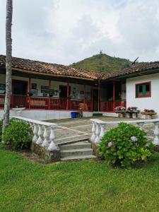 une maison avec une terrasse couverte et des escaliers en face de celle-ci dans l'établissement Finca La Playa Ecohotel - Experiencia Campestre -, à Salento