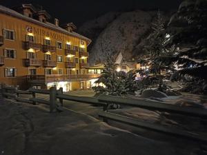 un hotel di notte con un albero di Natale e una recinzione di Le Miramonti Hotel Restaurant & Wellness a La Thuile