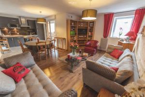 a living room with a couch and chairs and a table at L'Appart de Lary in Saint-Lary-Soulan