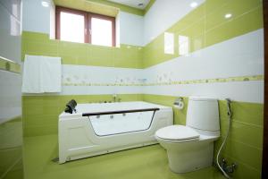 a green and white bathroom with a toilet and a window at Royal Palace Hotel in Vanadzor +86 photos
