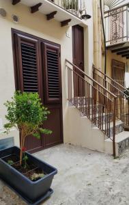 een huis met een potboom voor een deur bij La Nicuzza-#historicalhouse in Agrigento