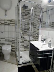 een badkamer met een douche, een wastafel en een toilet bij La Nicuzza-#historicalhouse in Agrigento