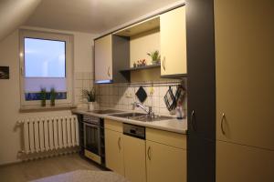 a kitchen with white cabinets and a sink and a window at Ferienwohnung im Harz in Wienrode