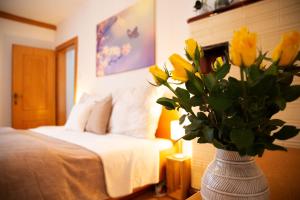 a vase filled with yellow flowers in a bedroom at Apartments Marie A in Hallstatt