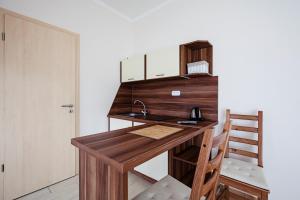 a kitchen with a wooden desk and a sink at Kocsis Apartman és Camping in Mosonmagyaróvár