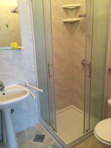 a shower in a bathroom with a sink and a toilet at Guest House Renata in Plomin