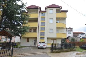 a yellow and white building with a car parked in front at Apartments Evroski in Ohrid