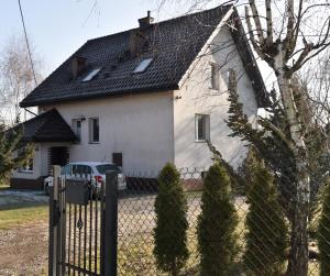 a white house with a fence in front of it at VIP apartment in Mogilany close to Kraków Air con WLAN Highspeed in Mogilany