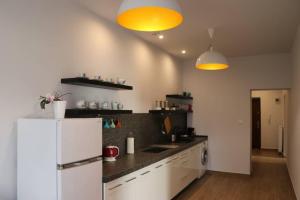 a kitchen with a white refrigerator and two lights at Apartament Family in Tarnowskie Góry