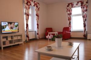 a living room with a tv and a table at Apartament Family in Tarnowskie Góry