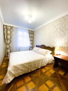 a bedroom with a large bed and a desk at Apartment Ryadom S Ploshadiu Rynok in Lviv