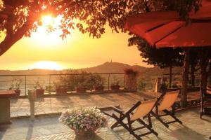 un patio con 2 sillas y una puesta de sol en el fondo en B&B Il giardino di Armida en Ogliastro Cilento