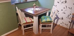 a small table with two chairs and a small table with at Ferienwohnung Prinz in Lathen