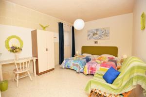 a bedroom with two twin beds and a desk at Avalon - Bellevue Gozo in Xlendi