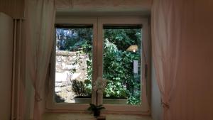 una finestra con vista sul giardino in una camera di Ljubljana City Centre Apartment a Lubiana