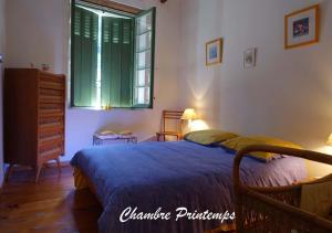 a bedroom with a bed and a window and a dresser at Gîte rural La Bergerie du Sant in Massaguel