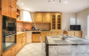 a kitchen with wooden cabinets and a table with chairs at Cozy Home In Algajola With Wifi in Algajola