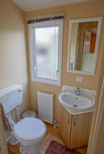 a bathroom with a toilet and a sink and a window at Rio Stratford-Upon-Avon in Stratford-upon-Avon