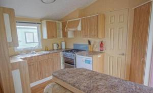 a kitchen with wooden cabinets and a stove top oven at Rio Stratford-Upon-Avon in Stratford-upon-Avon