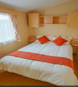 a bedroom with a large white bed with orange pillows at Rio Stratford-Upon-Avon in Stratford-upon-Avon