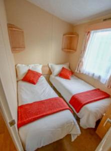 two beds in a small room with a window at Rio Stratford-Upon-Avon in Stratford-upon-Avon