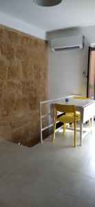 een eetkamer met een tafel en een gele bank bij La Nicuzza-#historicalhouse in Agrigento