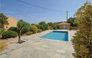 a swimming pool in a yard next to a house at Cozy Home In Algajola With Wifi in Algajola +15 photos